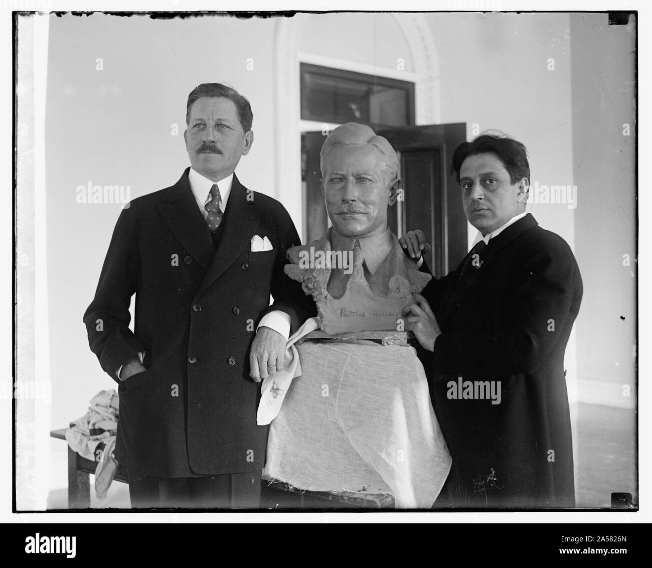 Segretario di guerra pone per il busto di noti scultore. Il segretario della guerra Patrick J. Hurley in posa per il tocco finale di un busto di se stesso che è in via di completamento per le mani di Edgardo Simone, notato scultore italiano, che è stata la modellazione di un certo numero di personaggi di spicco nel suo studio di Washington Foto Stock