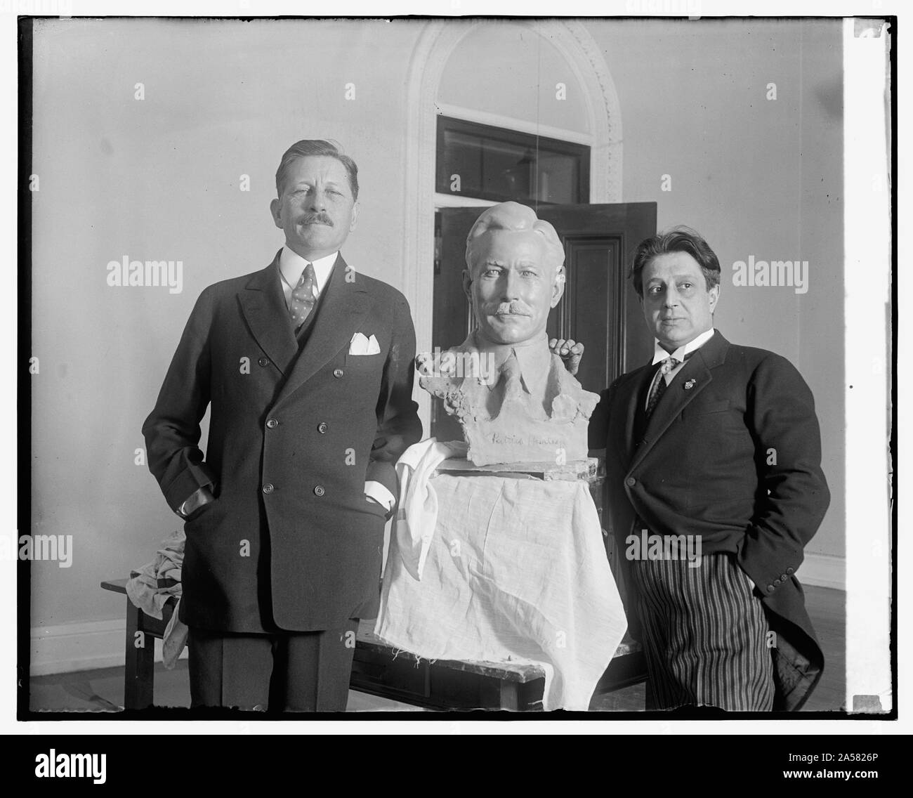 Segretario di guerra pone per il busto di noti scultore. Il segretario della guerra Patrick J. Hurley in posa per il tocco finale di un busto di se stesso che è in via di completamento per le mani di Edgardo Simone, notato scultore italiano, che è stata la modellazione di un certo numero di personaggi di spicco al suo stucio a Washington Foto Stock