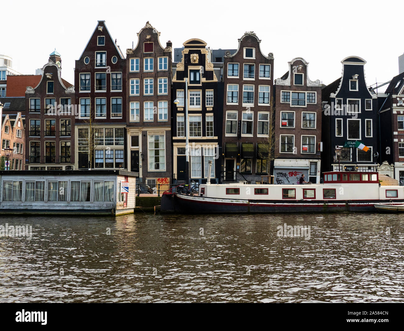 Tradizionali case cittadine Olandesi lungo il fiume Amstel waterfront, Amsterdam, Olanda Settentrionale, Paesi Bassi Foto Stock
