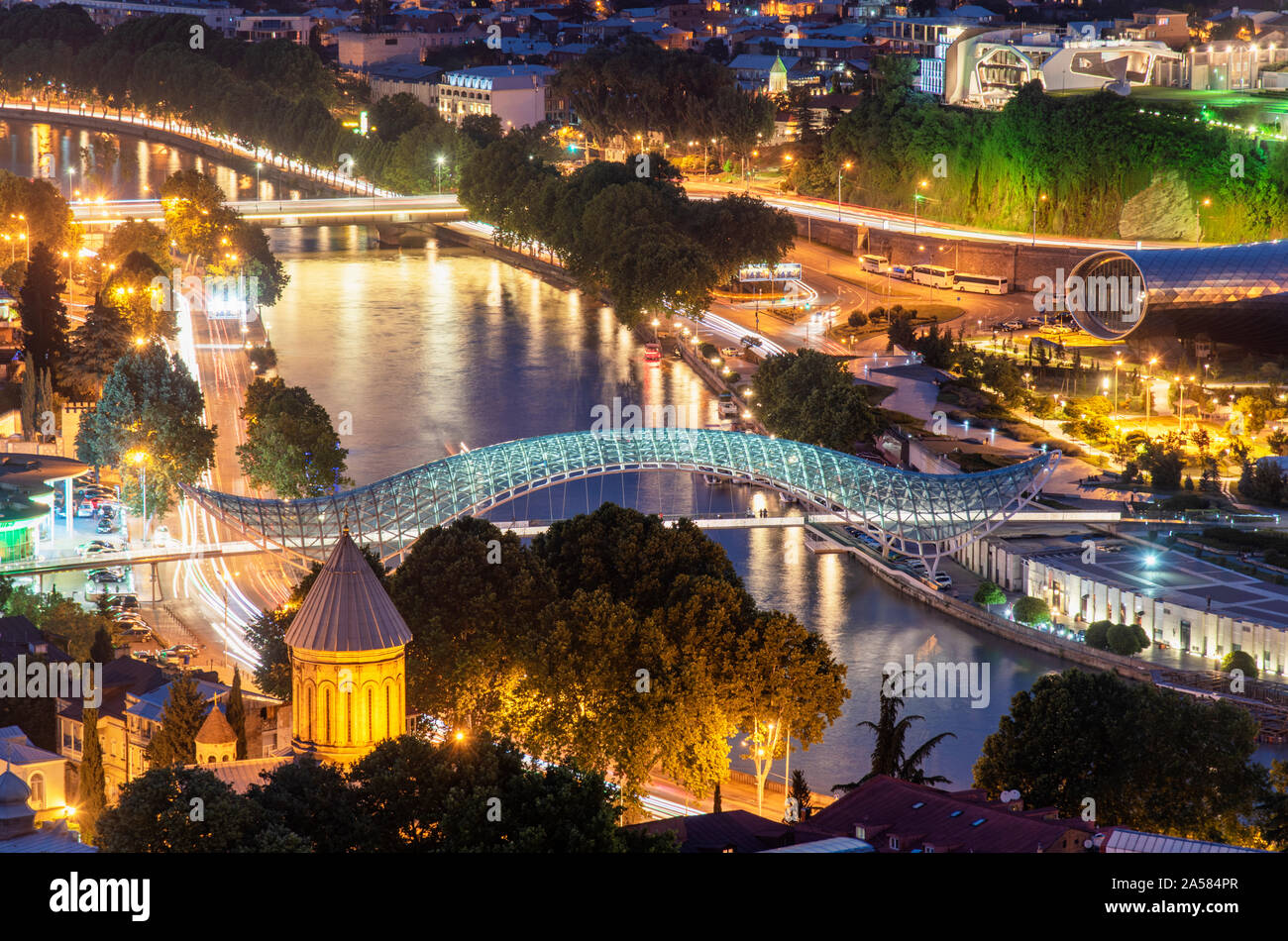 Ponte di Pace e il fiume Mtkvari. Sulla destra, il Parco Rike Musica Teatro e Sala delle Esposizioni ed il Palazzo Presidenziale. Tbilisi, Georgia. Foto Stock