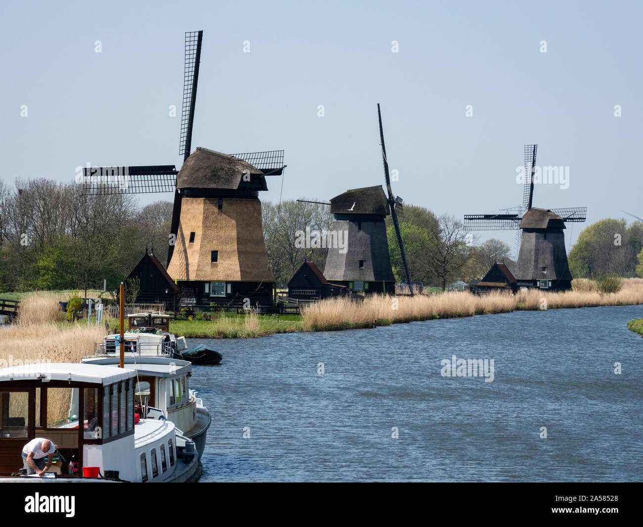 Tre mulini a vento sulla riva del canale, Rustenberg, North Holland, Paesi Bassi Foto Stock