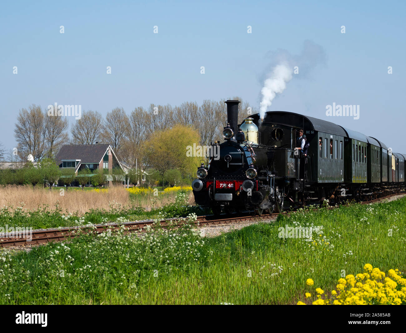 Il vecchio treno a vapore in movimento lungo i binari della ferrovia in zona rurale, Boerdijk, North Holland, Paesi Bassi Foto Stock