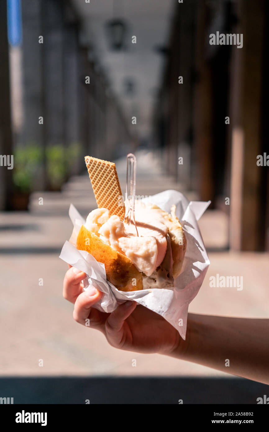 Giovane donna, turista in possesso di gelato o gelato in brioche tradizionale strada siciliana dessert a Palermo. Foto Stock