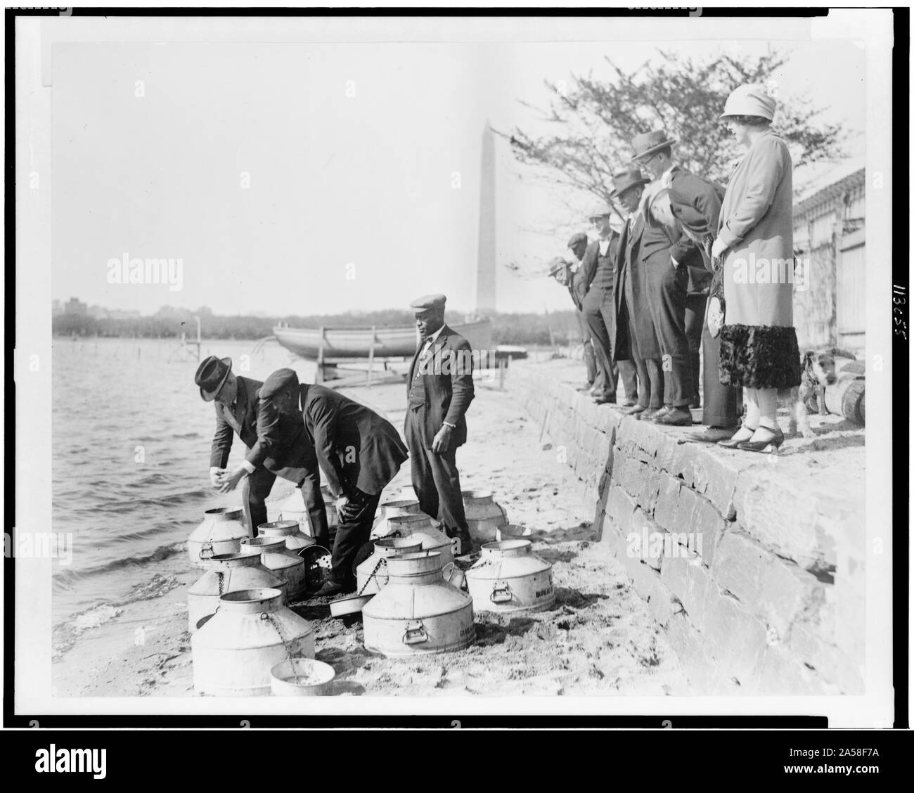 Stati Uniti Il Commissario di pesce, Henry O'Malley, coefficiente di pescare nel fiume Potomac, presso il bacino di marea, Washington, D.C., con il Monumento a Washington in background Foto Stock
