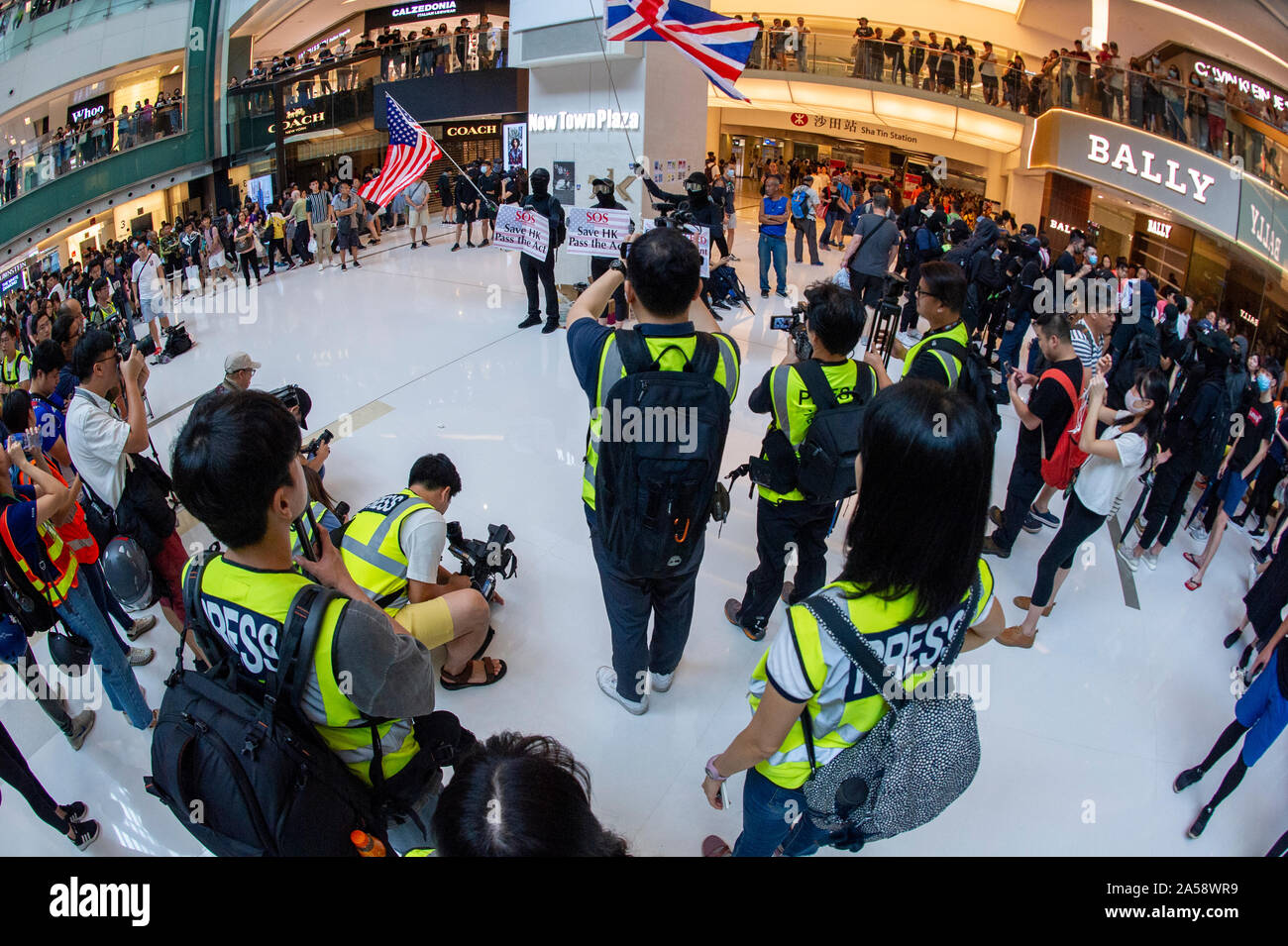 Hong Kong contestatori wave inglesi e americani le bandiere in segno di protesta in un centro commerciale per lo shopping di Hong Kong prima di violenza erutta Foto Stock