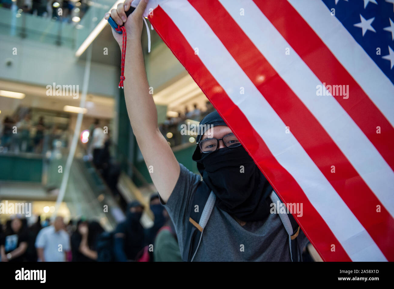 Hong Kong contestatori wave inglesi e americani le bandiere in segno di protesta in un centro commerciale per lo shopping di Hong Kong prima di violenza erutta Foto Stock