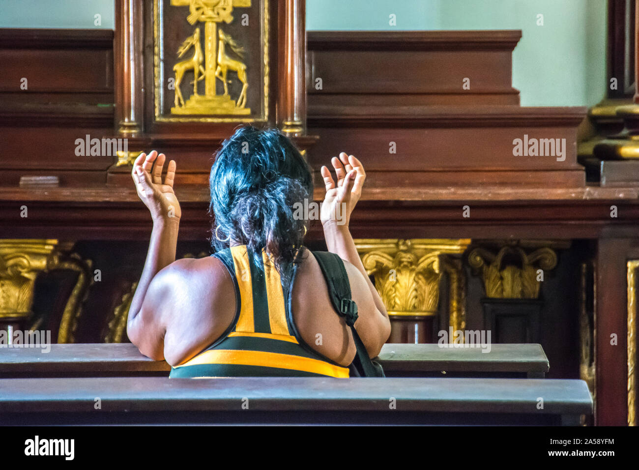 Una donna in adorazione nella chiesa. Camaguey, Cuba. Foto Stock