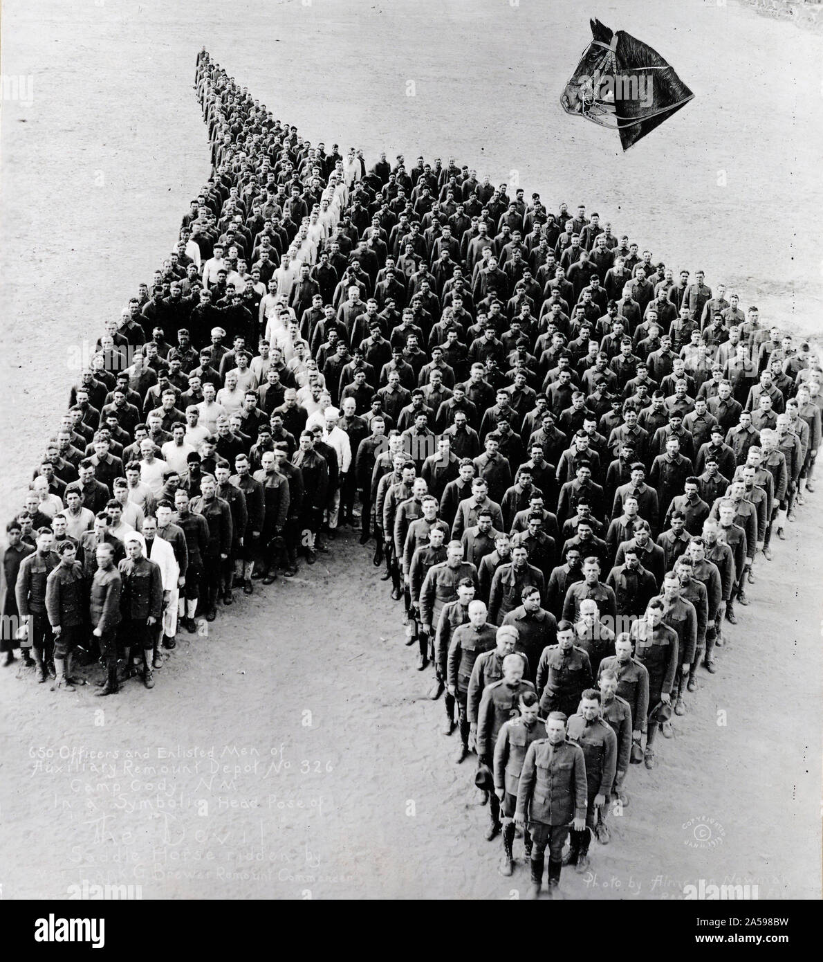 650 ufficiali e uomini di rimontare Depot #326, Camp Cody, N.M., formata in un simbolo di testa di posa "diavolo", una sella cavallo cavalcato da Col. Frank C. Brewer, comandante della stazione di rimontare ca. 1920-1921 Foto Stock
