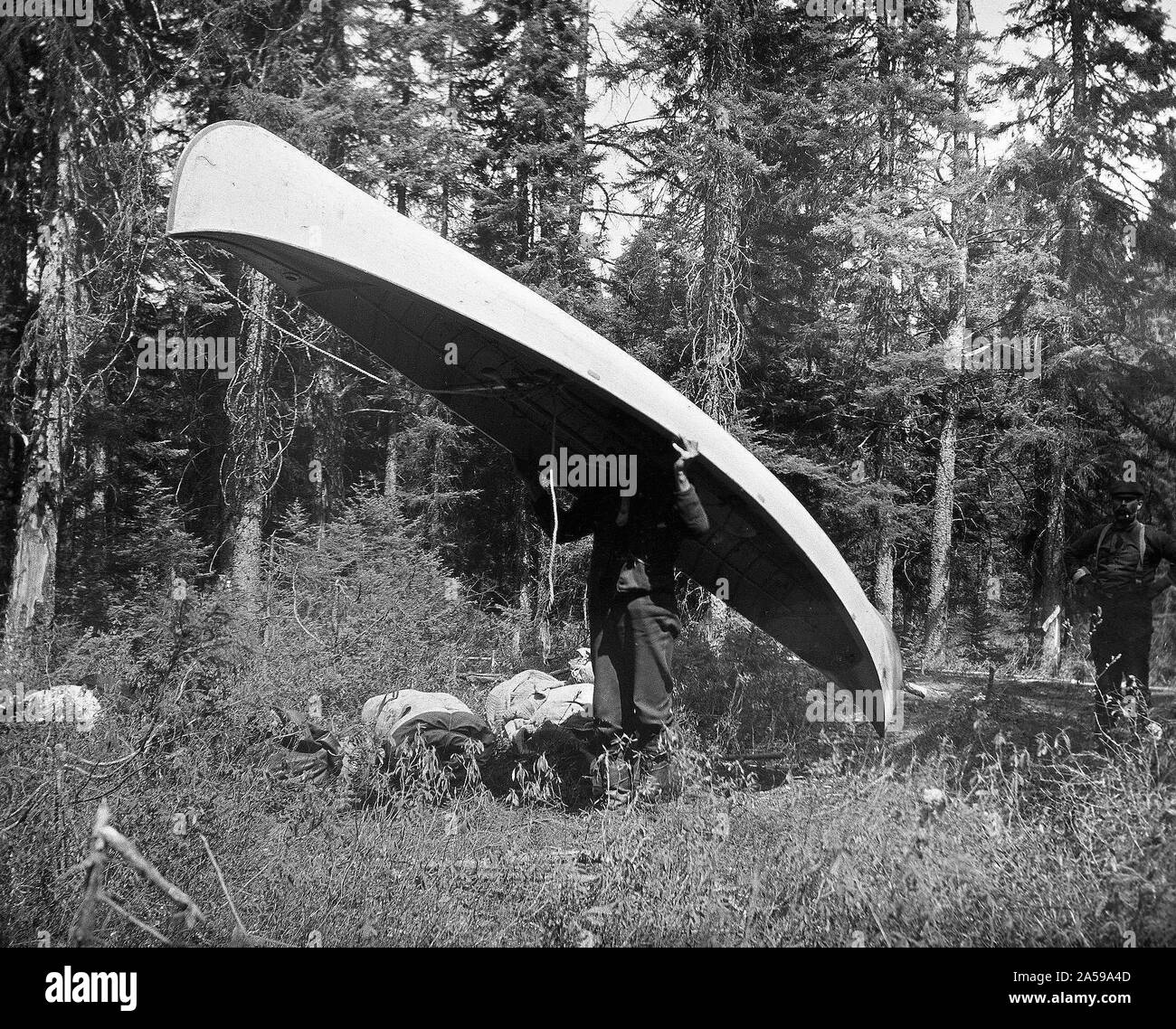 'Lungo Portage (1 2/3 miglia in Stillwater Lago)' uomo che porta una canoa ca. 1909 Foto Stock