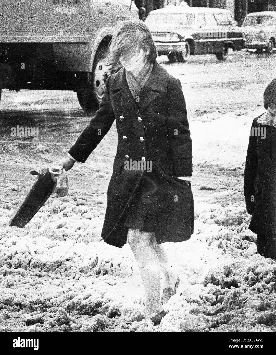 Donna Wind-Blown attraversando viscido Street Novembre 1966 Foto Stock