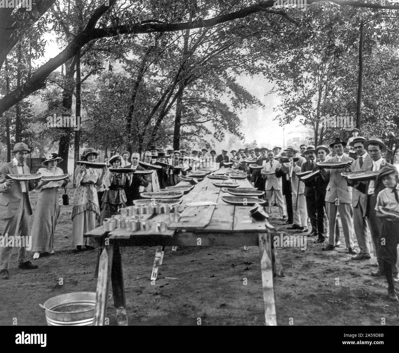 Gruppo di aziende grandi pezzi di cocomeri pone in piedi intorno a tavoli, Fairfield, Alabama 1917 Foto Stock