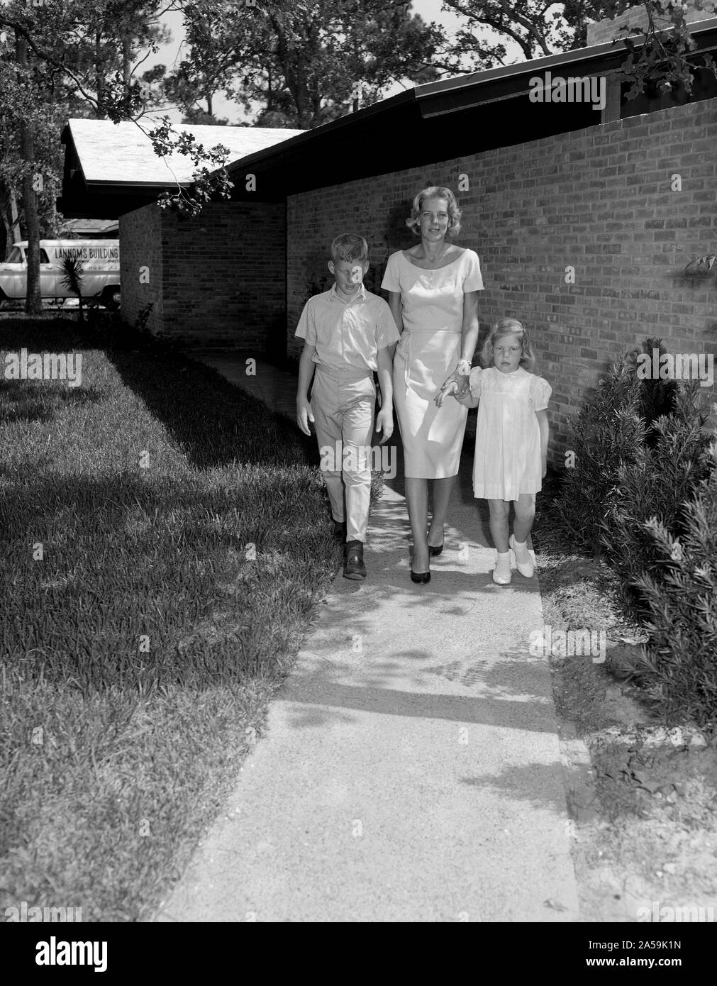 (1962) --- La signora Wally schirra e i suoi due figli di lasciare l'edificio Farnsworth-Chambers dopo una breve visita nel 1962. Foto Stock