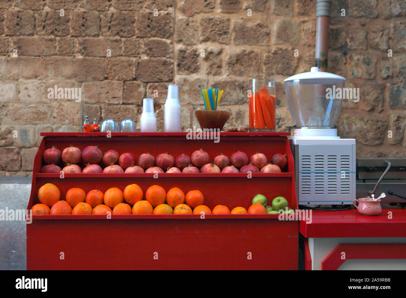 Un bar con succhi a strada - freschi succhi di frutta refrigerate in bicchieri di plastica, una rinomata cucina di strada nella città di Akko in Israele Foto Stock