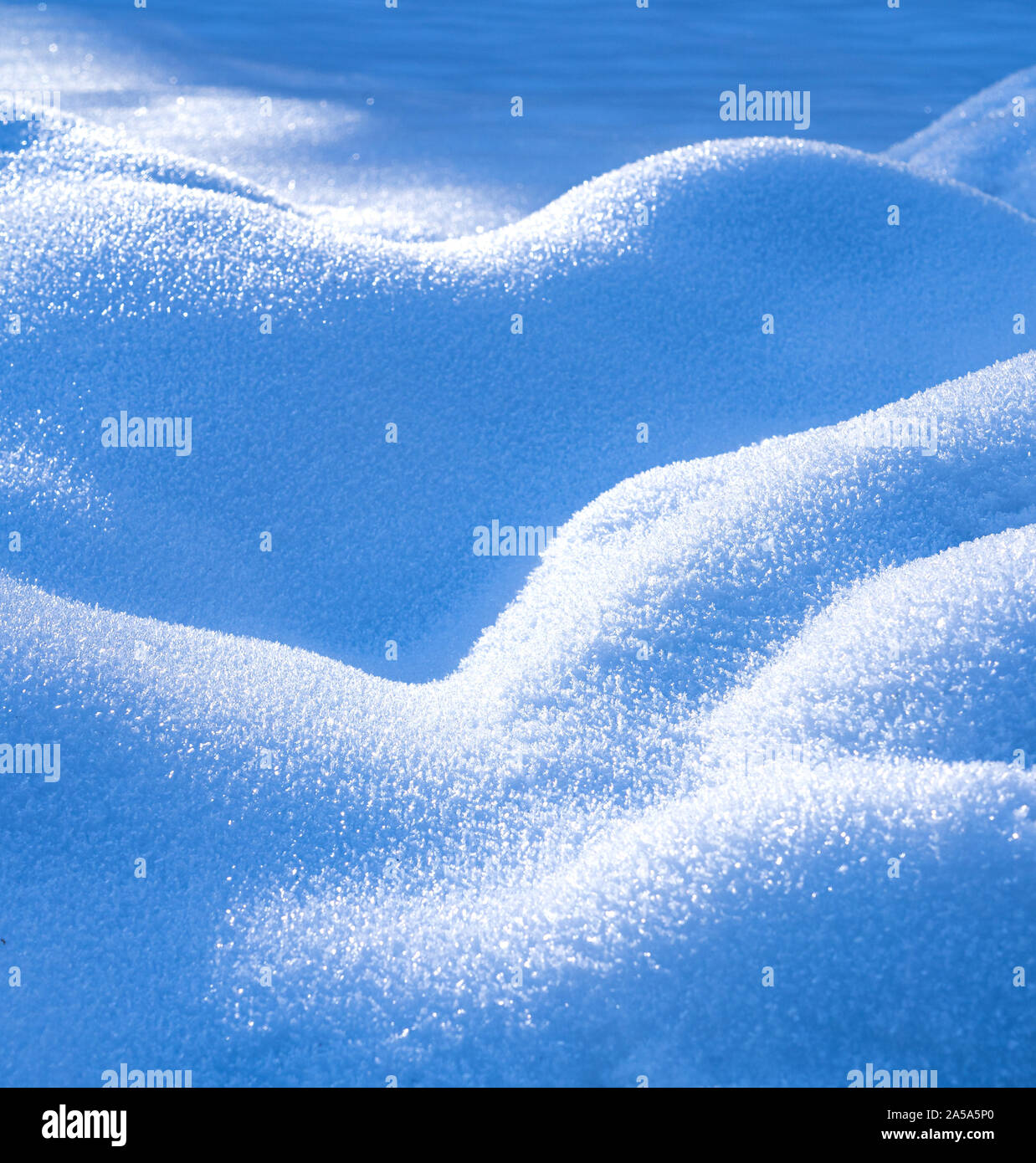 Una vista astratta su una struttura ondulata generata dal vento sulla neve con ghiaccio crysals visble sulla superficie Foto Stock