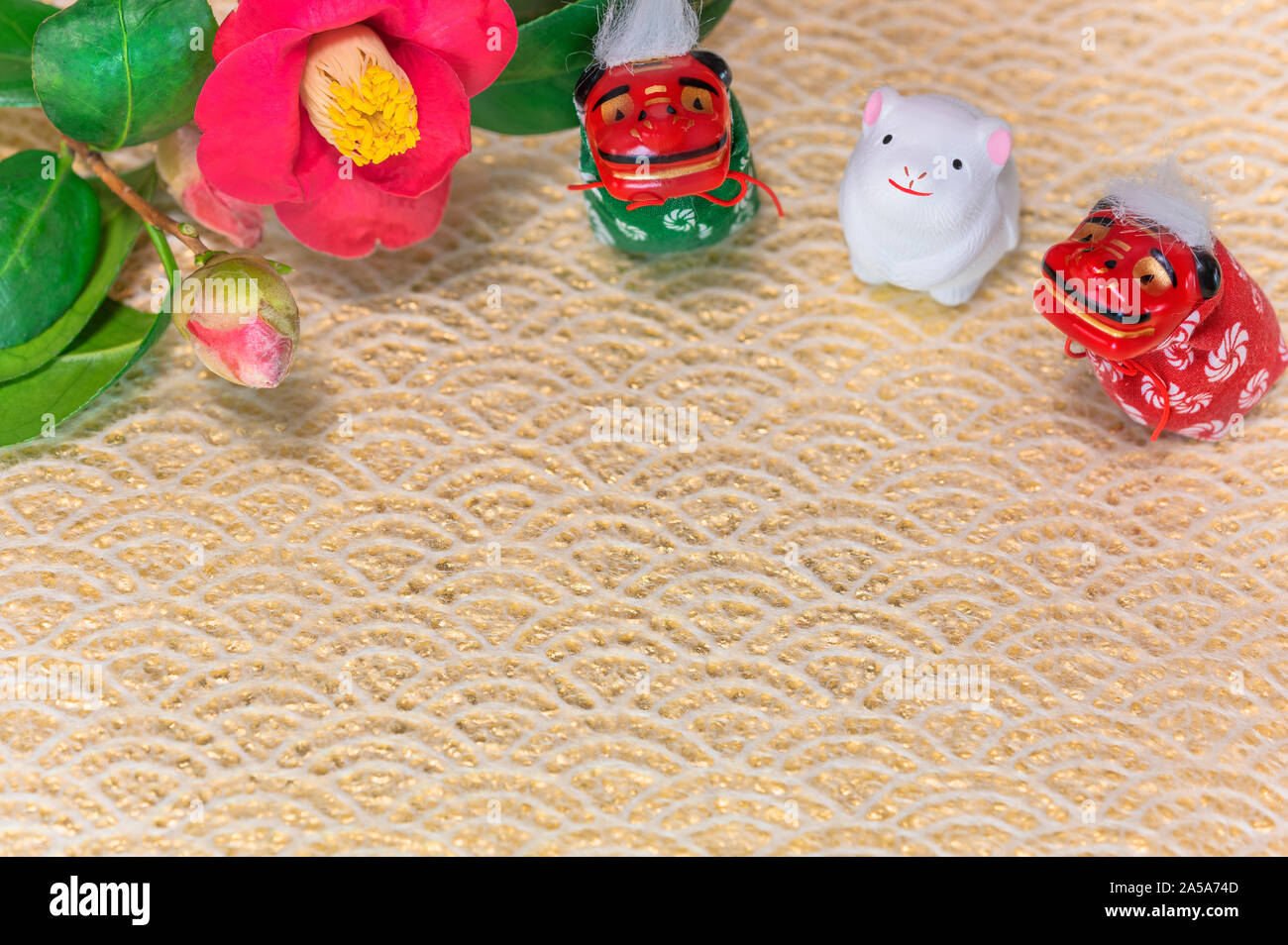 Un giapponese di biglietto di auguri con un fiore di Tsubaki chiamato anche il winter rose e tre animali Folklore statuette raffiguranti due Shishimai lion e un taglio Foto Stock
