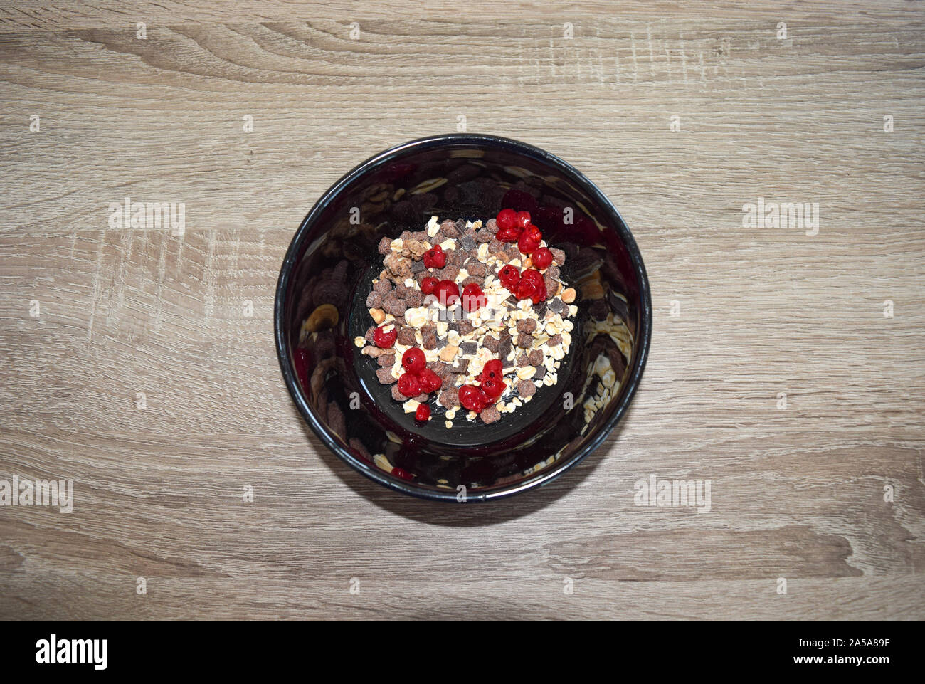 farinata d'avena con frutti di bosco freschi in un recipiente con cioccolato un tavolo Foto Stock