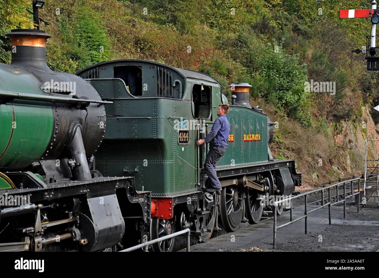 Il vapore loco guidatore sale nella cabina del GWR serbatoio prarie 4144 a Bewdley stazione sul Severn Valley Railway. Foto Stock
