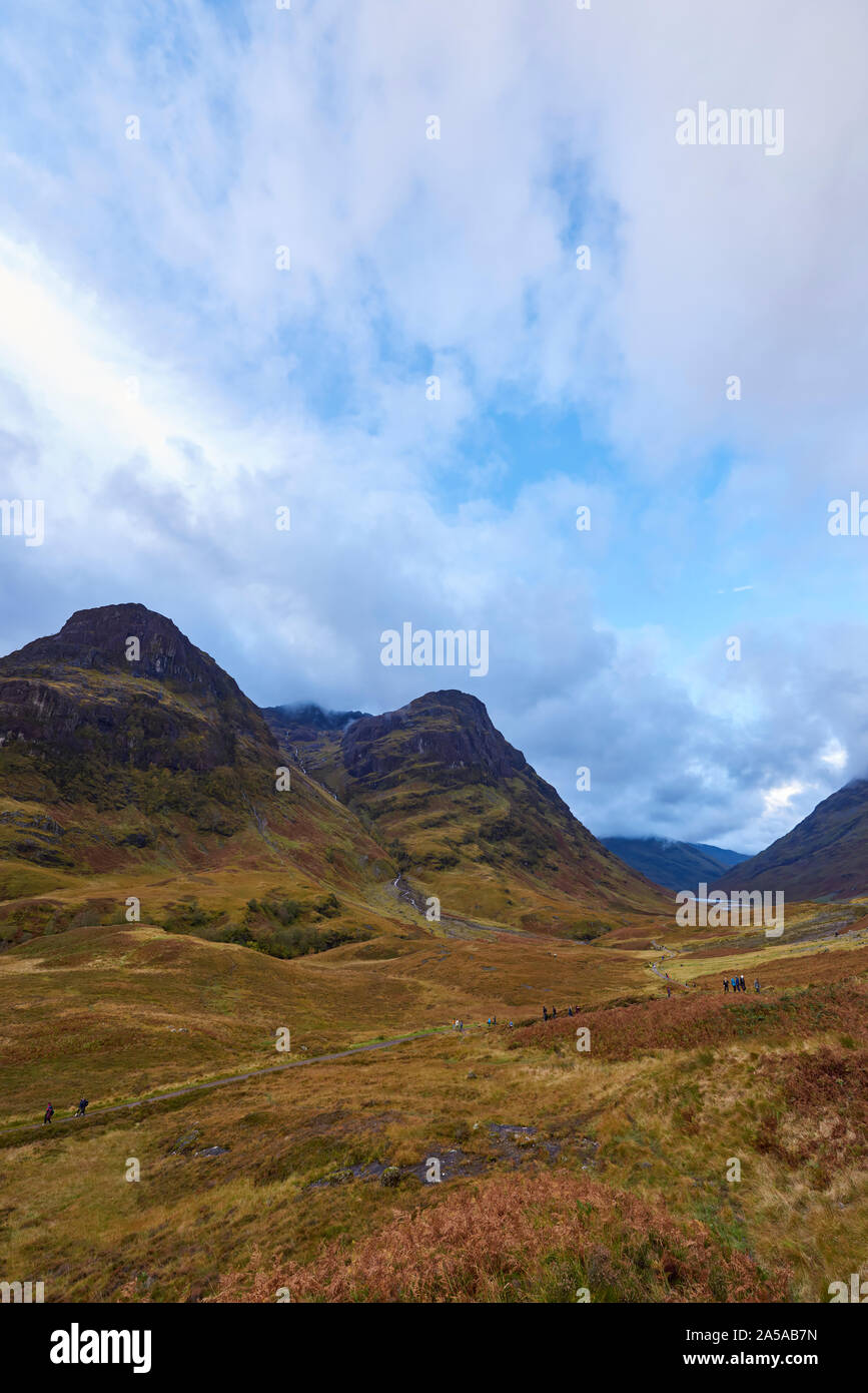 Guardando verso il basso Glencoe ad ovest, con il Walkers sul West Highland Way fanno il loro cammino lungo il sentiero su un umido ottobre giornata. Foto Stock