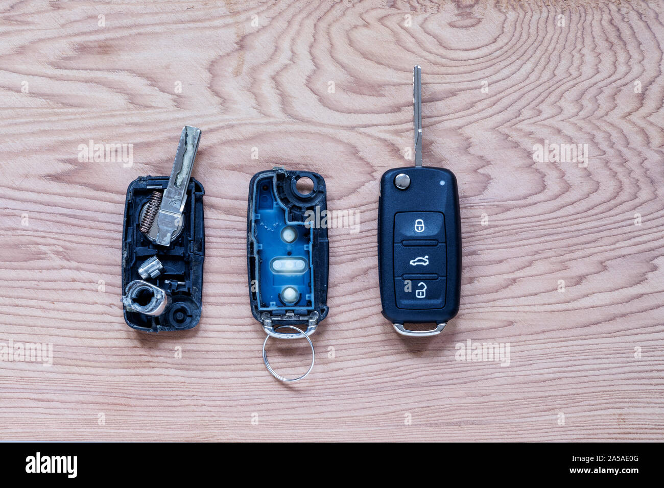 Rotto o danneggiato remote key fob e nuova chiave del veicolo su sfondo di legno. Rotto o danneggiato remote key fob di qualsiasi veicolo car service.- Immagine Foto Stock