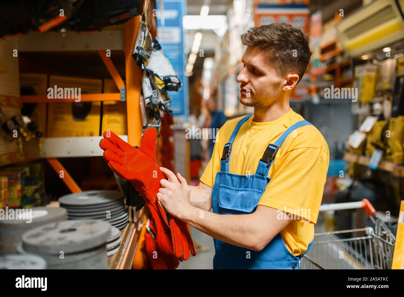 Builder maschio scelta di guanti in negozio di ferramenta Foto Stock