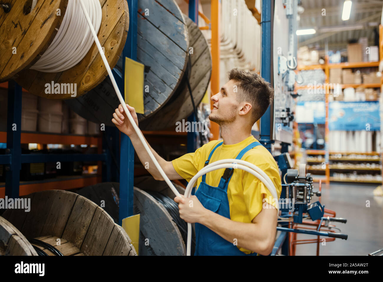 Builder maschio scegliendo i fili nel negozio di ferramenta Foto Stock