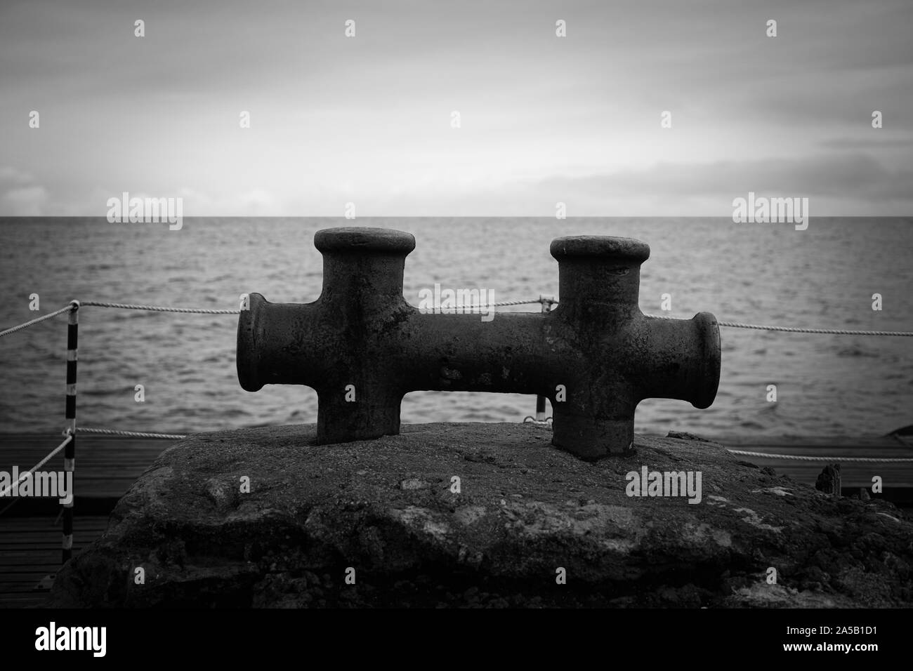 Marine ormeggio vecchio post su un ormeggio in bianco e nero Foto Stock