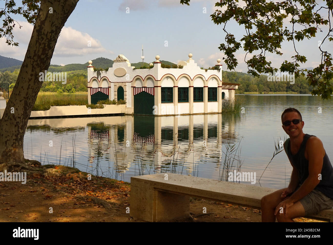 Uomo che posano per una foto di bella casa galleggiante sul lago di Banyoles Foto Stock