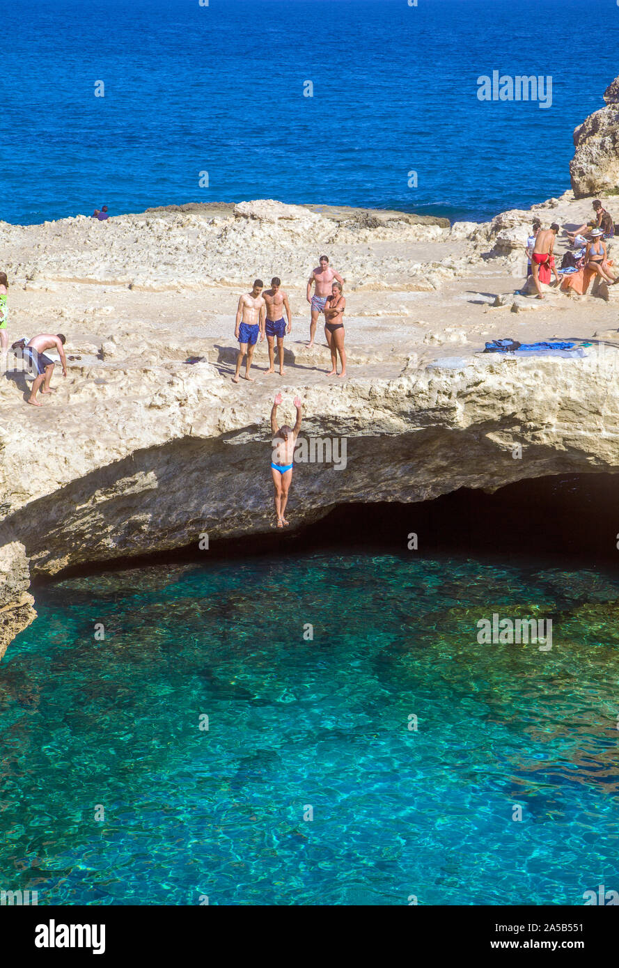 L uomo un salto nella grotta della poesia, una famosa piscina naturale, Roca Vecchia, Melendugno, Lecce, Puglia, Italia Foto Stock