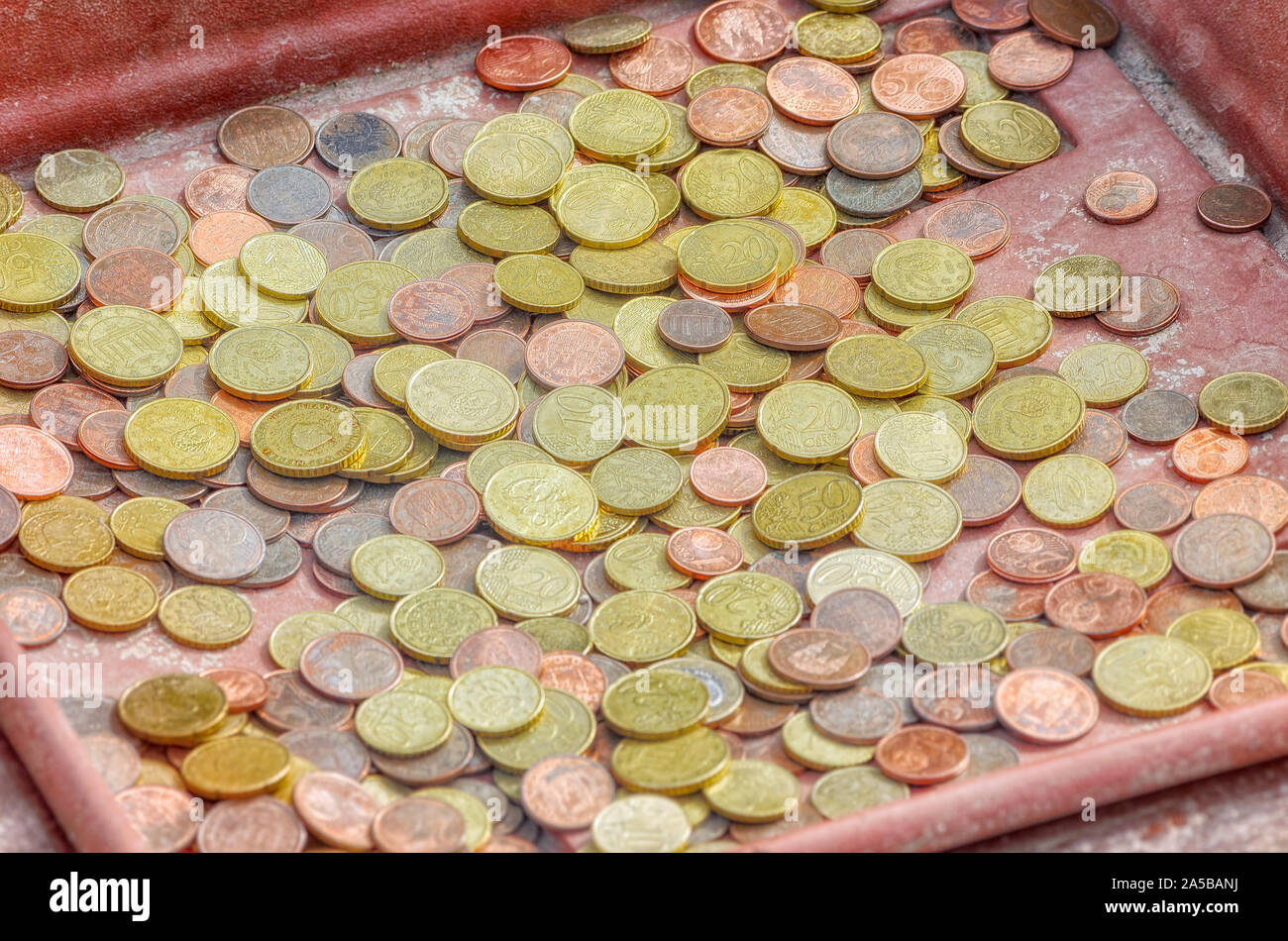 Un sacco di monete in un vassoio. Centesimi di euro (frazioni di 50, 20, 10, 5, 2 e 1). Scena all'aperto in un giorno nuvoloso. Foto Stock