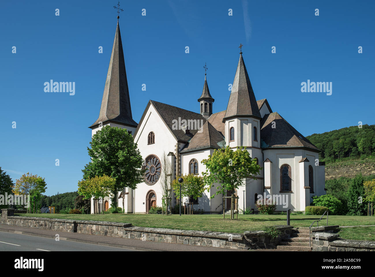 La chiesa di S. Martino in Olsberg Bigge. Un round in vetro piombato finestra sul lato sud. I tetti sono slated. Foto Stock