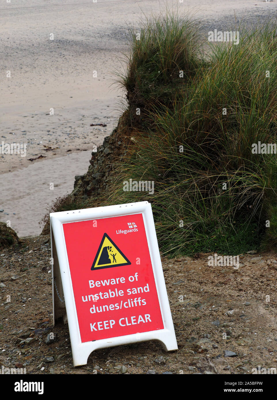 Scogliere instabili o dune di sabbia del segno di avvertimento a Gwithian Beach, Cornwall, Regno Unito. Foto Stock