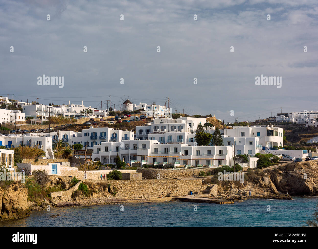 Punto di riferimento di edifici bianchi allineati sulla riva del mare nella città di Mykonos in Grecia Foto Stock