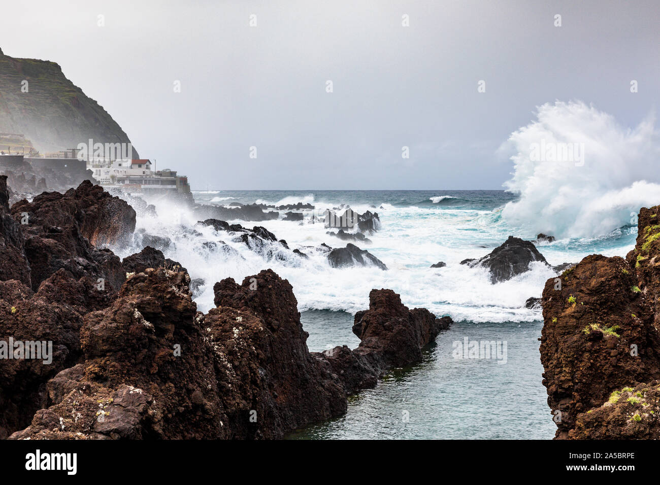 Onde infrangersi sulla roccia all'aperto oceano Atlantico acqua di mare piscine naturali di Porto Moniz, Madeira, Portogallo Foto Stock