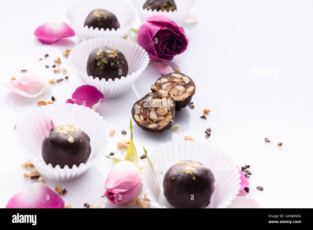 Caramelle di cioccolato con noci e miele. Deliziosi cioccolatini su uno sfondo bianco. Close-up. Soft focus. Spazio di copia Foto Stock