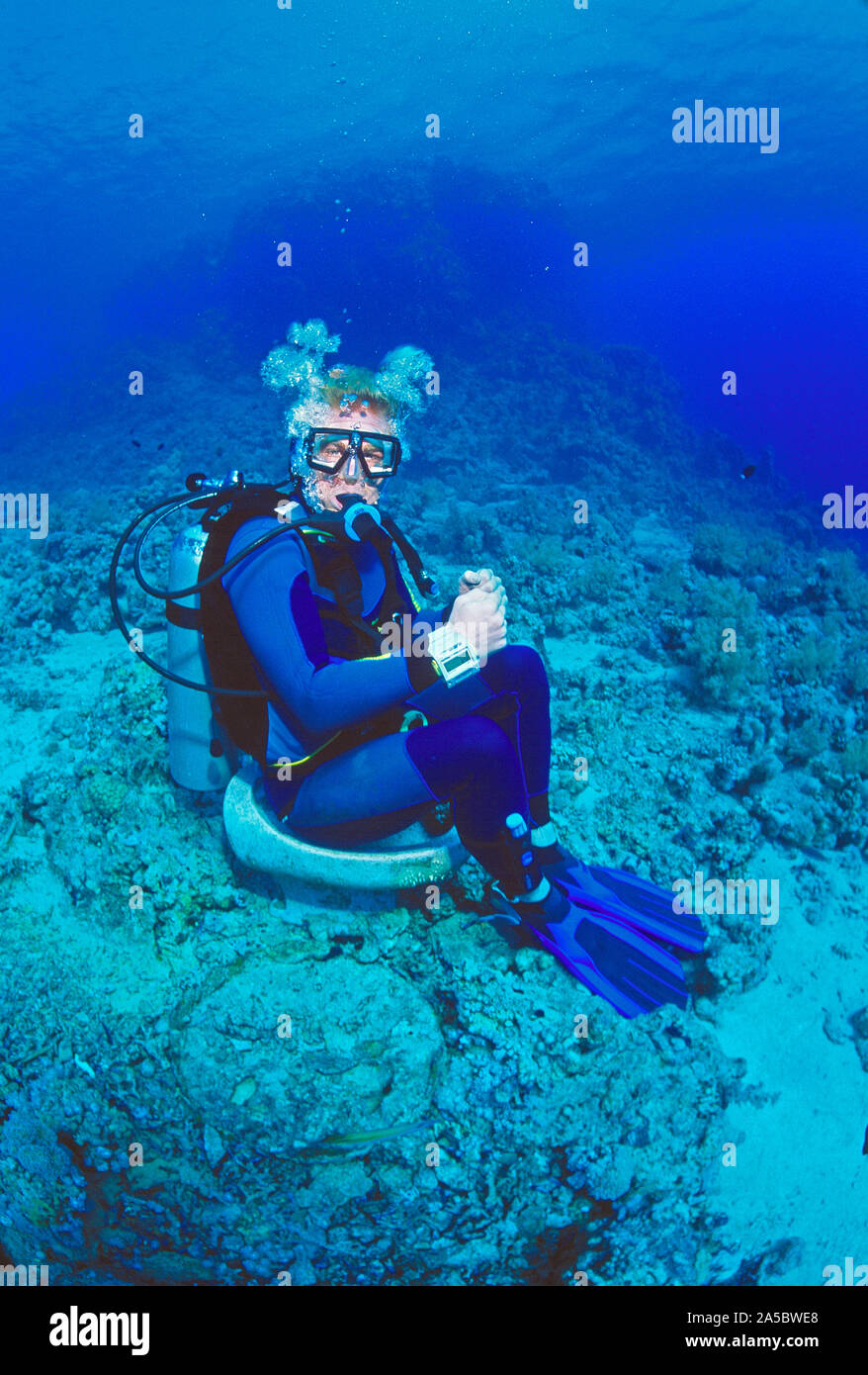 L'Egitto. Mar Rosso. Immersioni subacquee. Divertente immagine dell uomo seduto sul bidet sul naufragio. Foto Stock