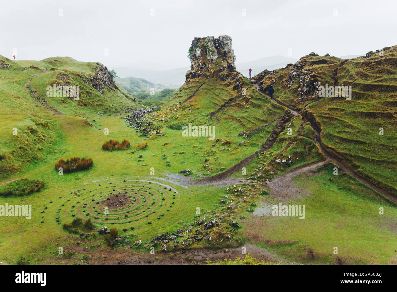 Cerchi di pietre e di percorsi twist attraverso l'erba incantevoli colline coperte di Fairy Glen, Isola di Skye in Scozia Foto Stock