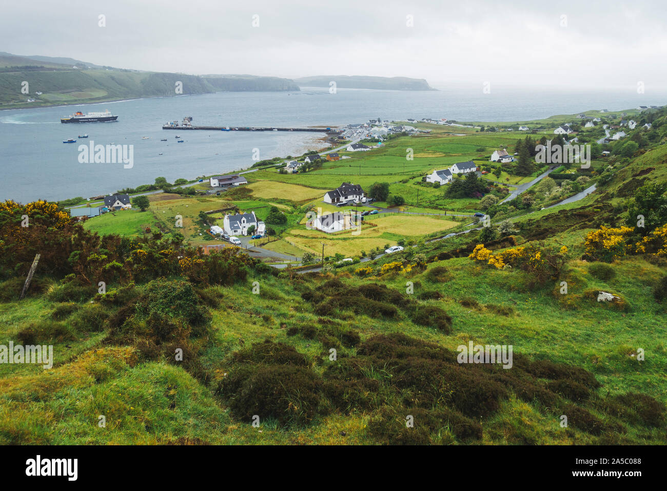 Il Uig - Tarbert ferry oscilla in alla porta nel villaggio di Uig sull'Isola di Skye in Scozia in una piovosa giornata di vento Foto Stock