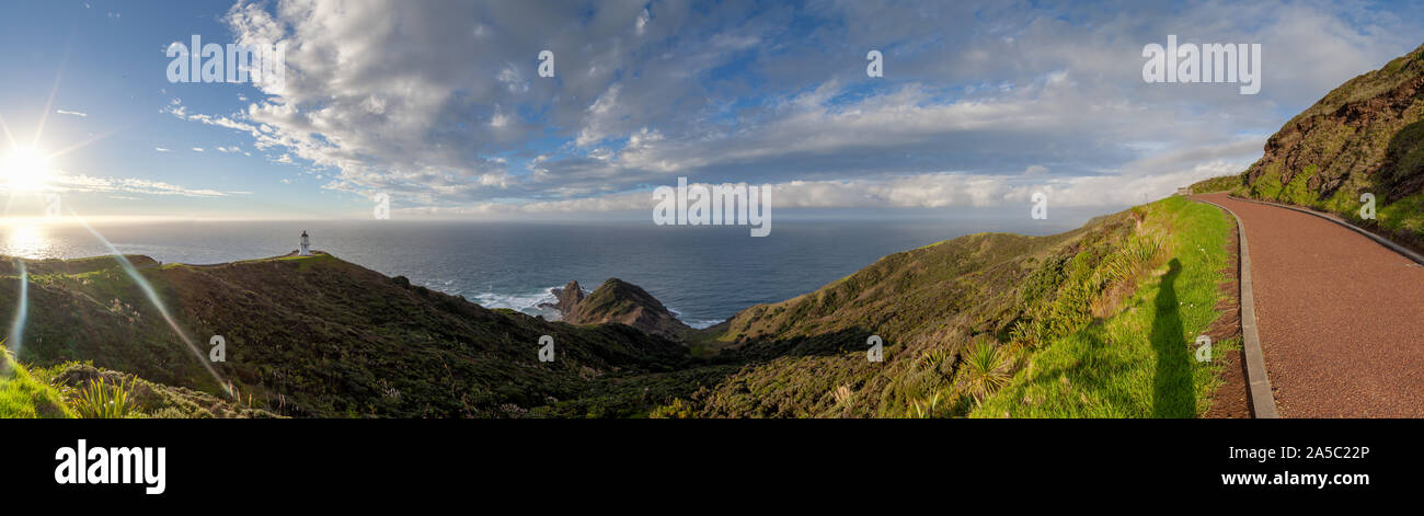 Cape Reinga, Te Rerenga Wairua, il punto più settentrionale della Nuova Zelanda dove il Mare di Tasman e Oceano Pacifico si incontrano, in sole serale con alcune nuvole. Foto Stock