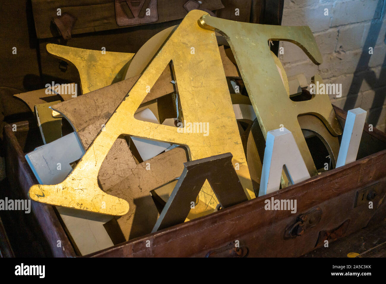 Oro coperto shop visualizza lettere in una valigetta in pelle Foto Stock