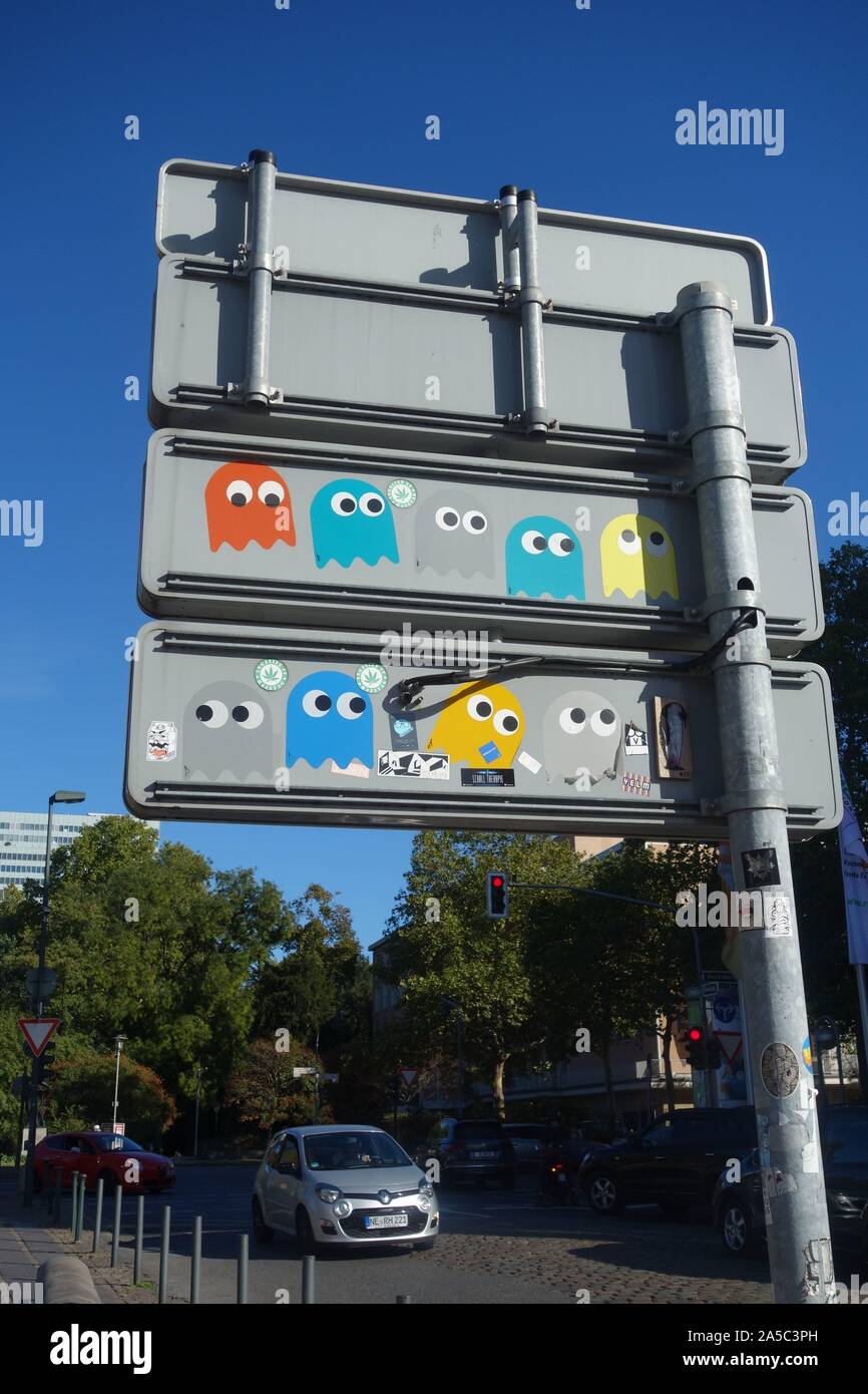 Pacman adesivi sul retro del cartello stradale a Dusseldorf. Gli adesivi sono opera di un artista di strada denominata Pdot e sono apparsi fin dal 2015. Foto Stock