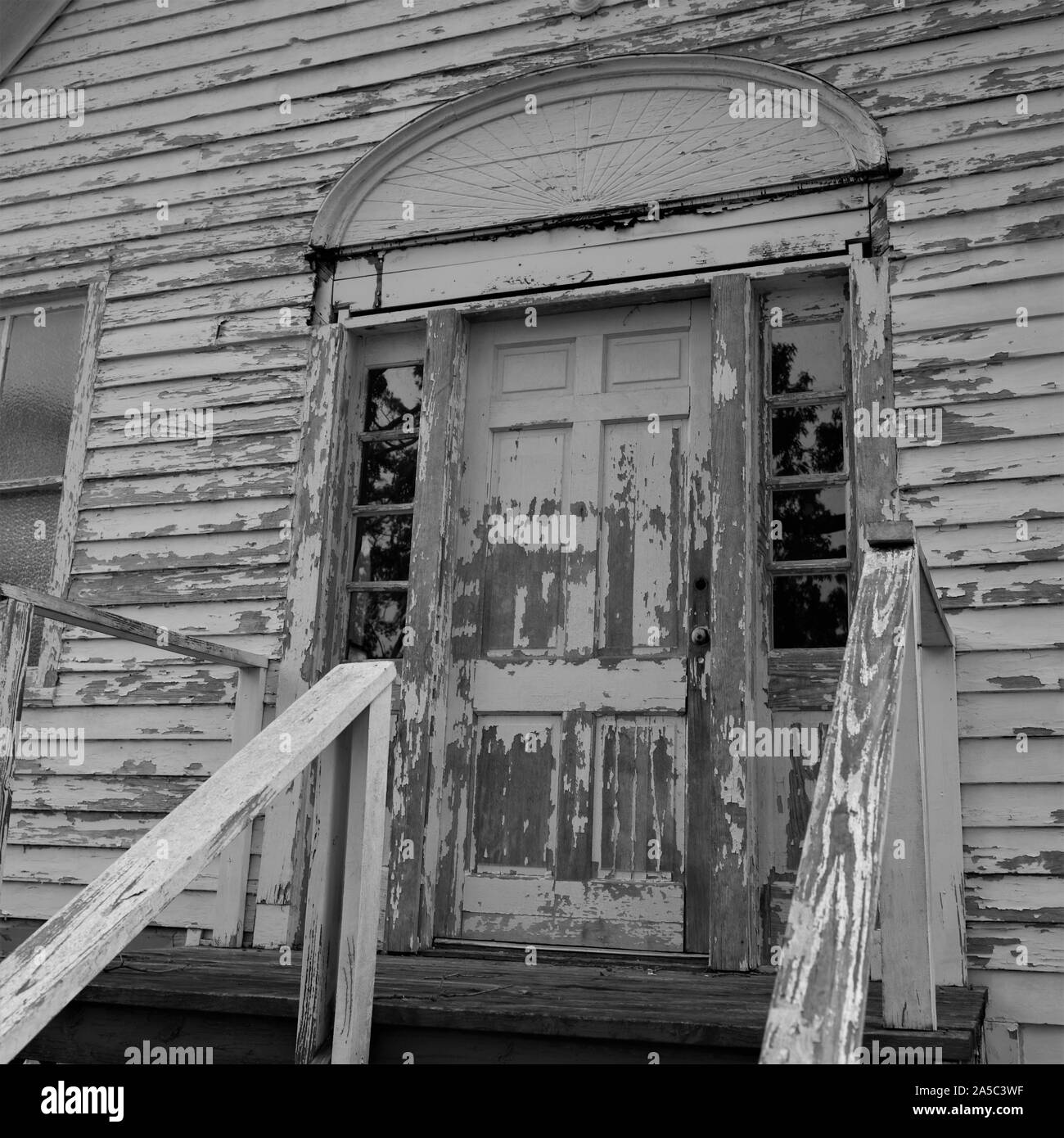 Una vecchia chiesa fatiscente si trova abbandonato in un lotto vacante. Foto Stock