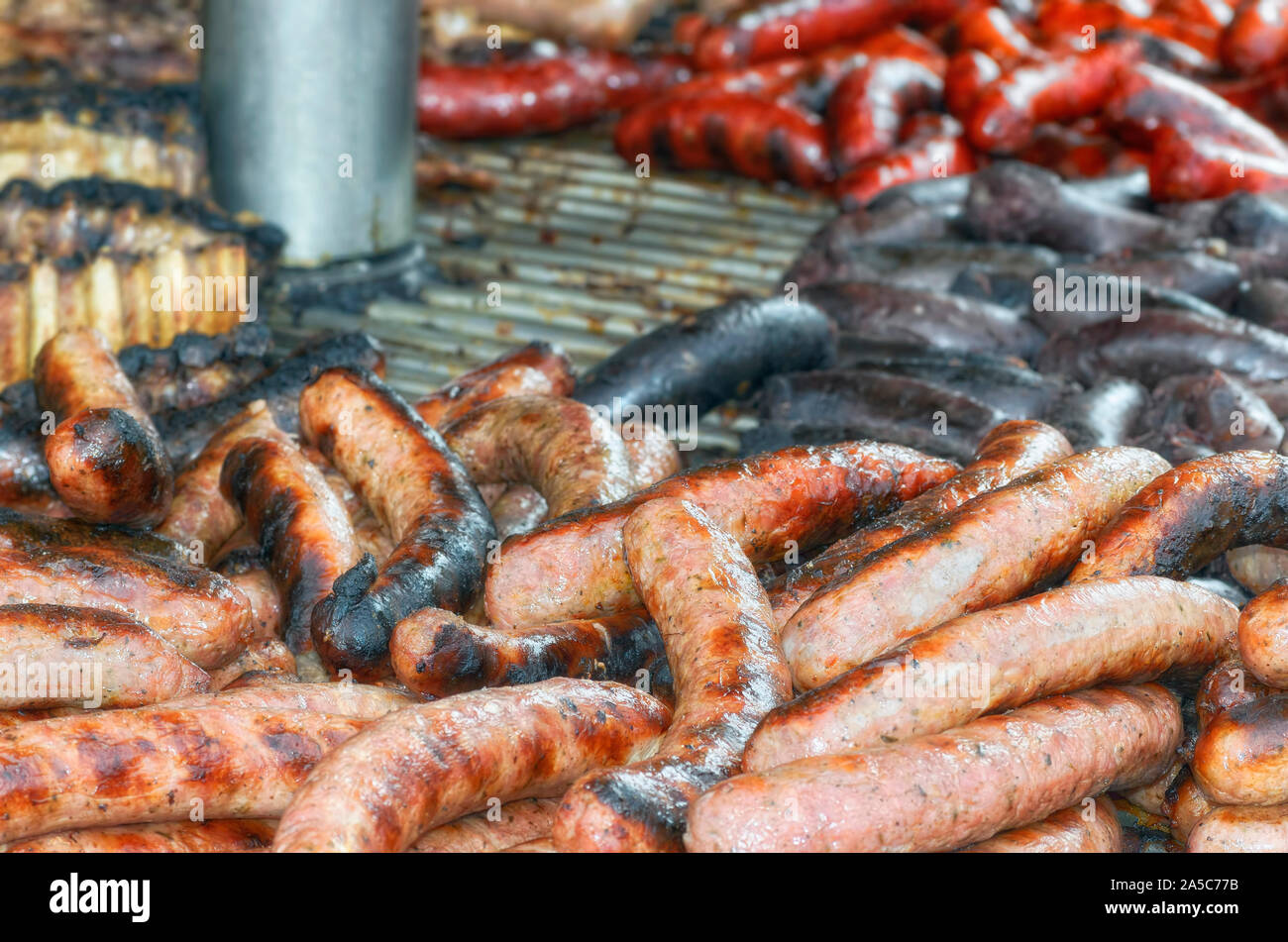 Alcune diverse carni cotte a all'aperto. Grande barbecue con salsiccia creolo, salsicce di sangue, salsiccia di maiale piccante e nervature. Cibi tipici della Spagna Foto Stock