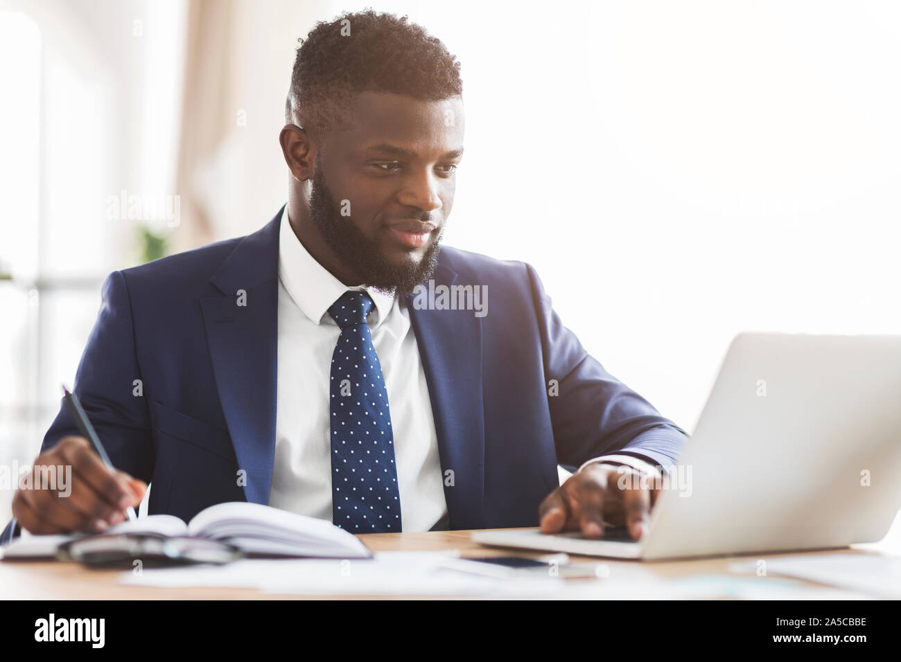 Giovani manager bello per il compimento di ricerche di mercato online Foto Stock