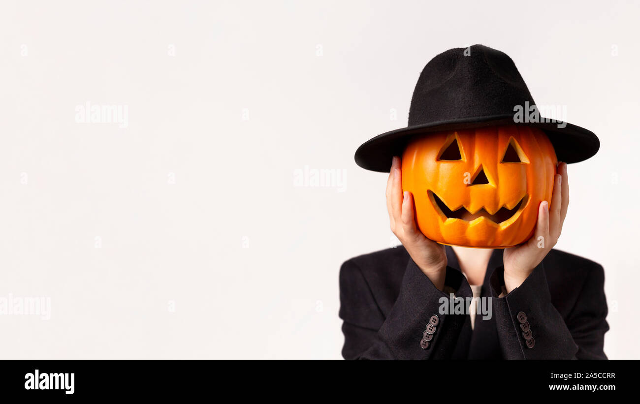 Man in black suit tenendo la testa di zucca in mani su bianco Foto Stock