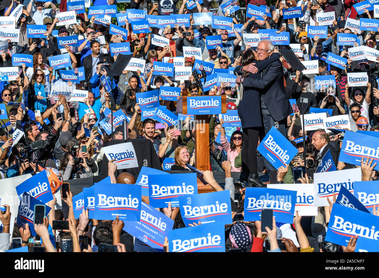 New York, Stati Uniti d'America, 19 ottobre 2019. Rappresentante Alessandria Ocasio-Cortez abbraccia il senatore Bernie Sanders nel Queens, a New York. Ocasio-Cortez vistato 2020 candidato presidenziale democratico Sanders nel suo primo rally dopo aver subito un attacco di cuore. Credito: Enrique Shore/Alamy Live News Foto Stock