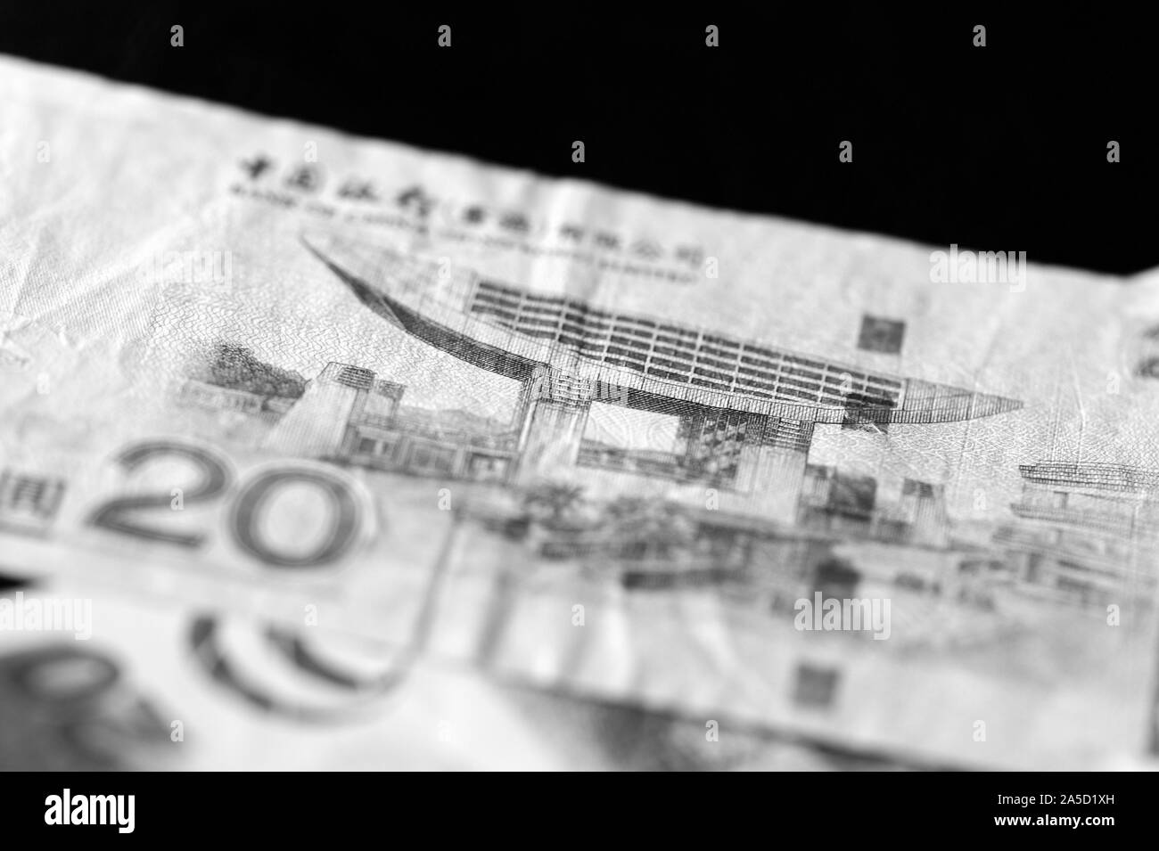 Due banconote di venti dollari di Hong Kong su uno sfondo scuro di close-up. In bianco e nero Foto Stock