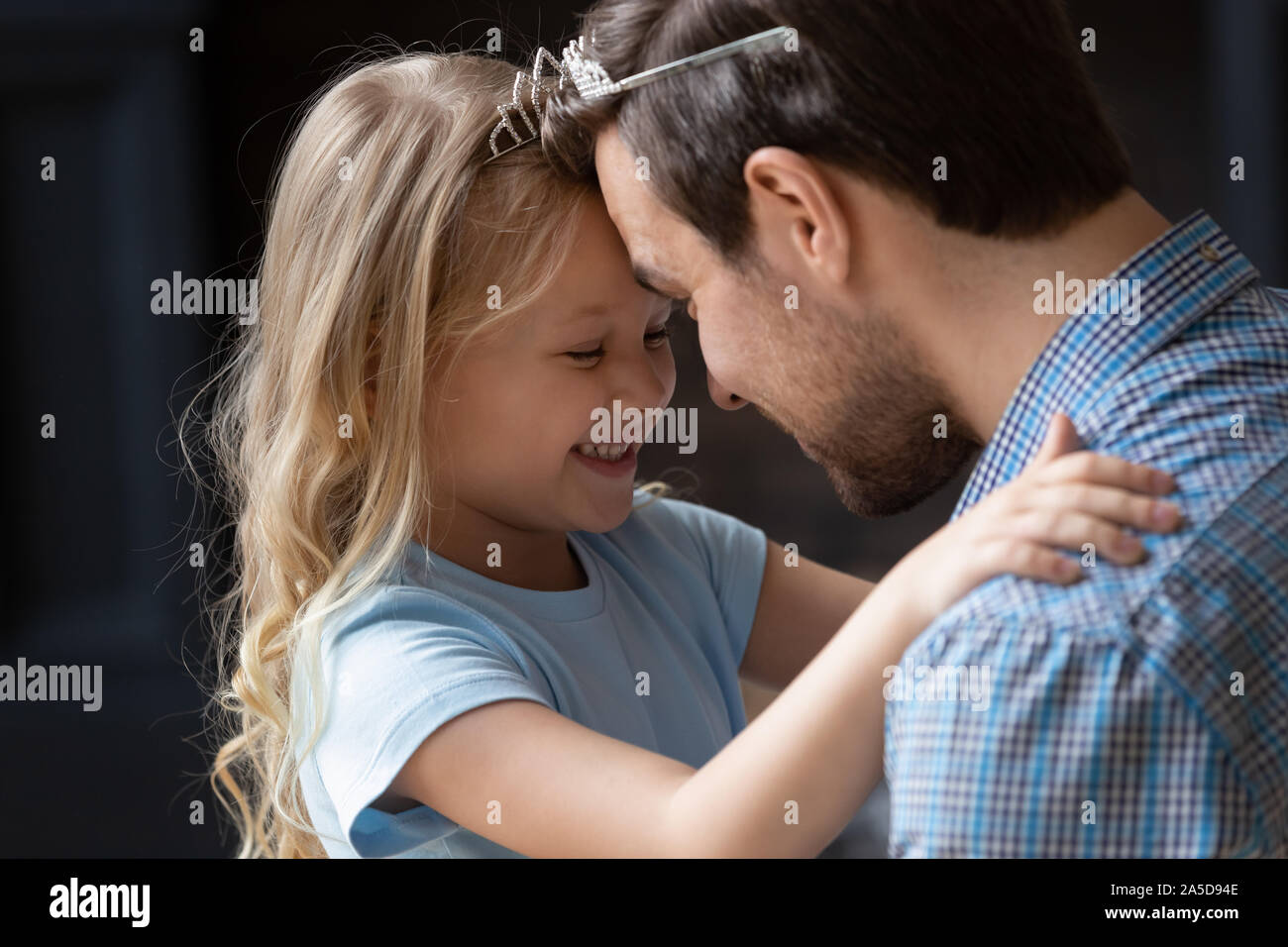 Close up adorabile piccola figlia e padre di toccare fronte Foto Stock