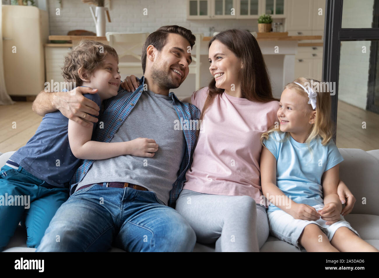 La famiglia felice costeggiata, madre e padre godendo di momento di gara Foto Stock