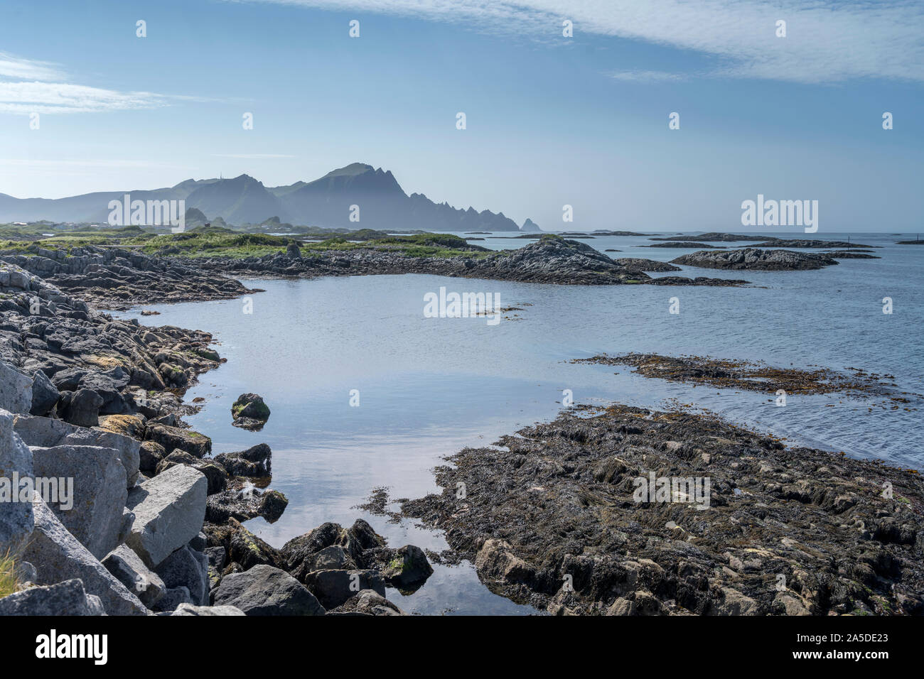 Paesaggio con rocce sparse in mare al di fuori della diga a villaggio Porto, girato sotto la luminosa luce estiva a Andenes, Andoya, Vesteralen, Norvegia Foto Stock