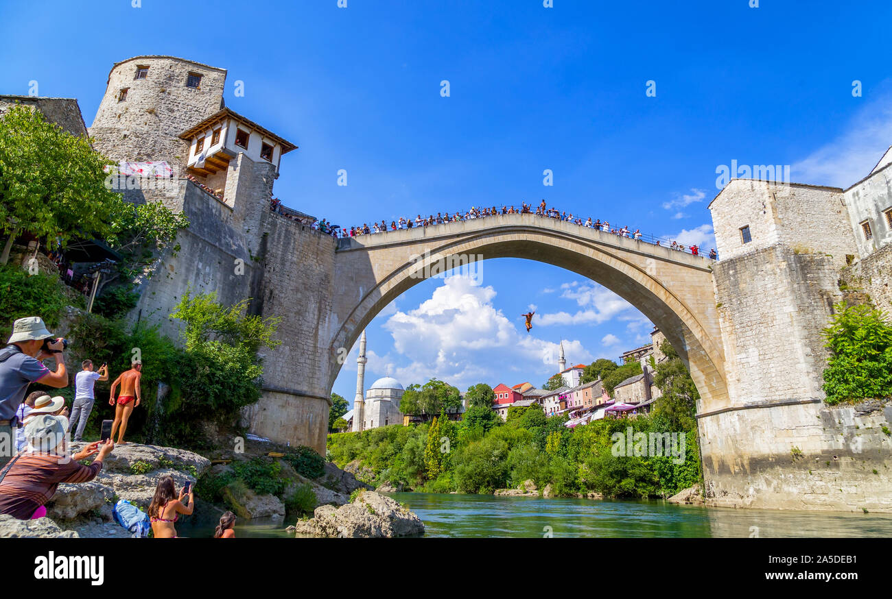 I turisti obiettivo telecamere come un sommozzatore bosniaco salto nel fiume Neretva dal Stari Most, il vecchio ponte di Mostar,Bosnia e Erzegovina,l'Europa,2019. Foto Stock